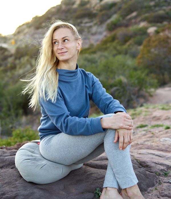 Woman in a calm, seated yoga pose, meditating in a serene environment.